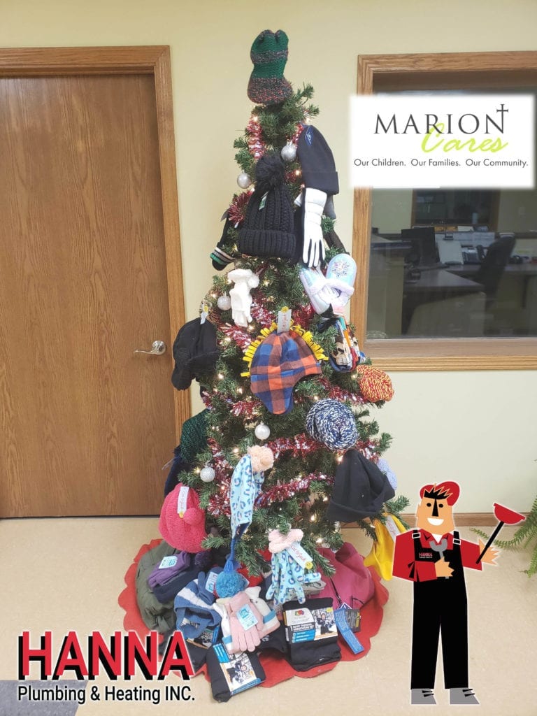 A christmas tree is covered in newly donated hats, gloves, and underwear.